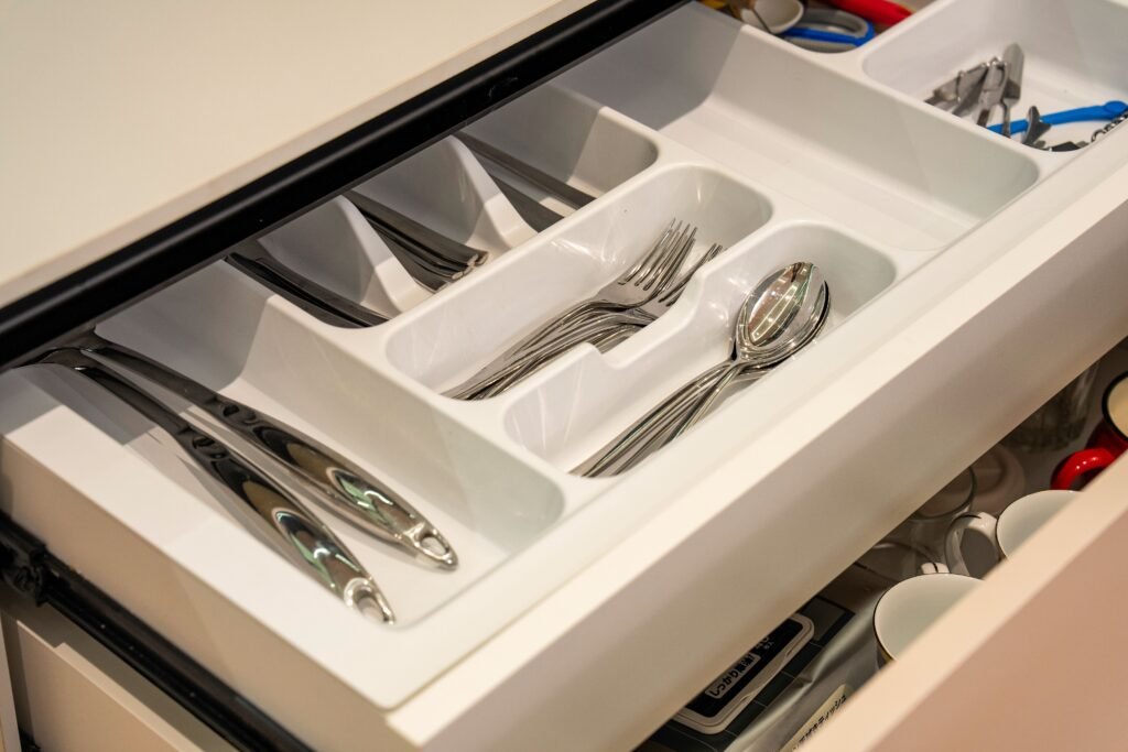 Open kitchen drawer with neatly organized spoons and everyday utensils