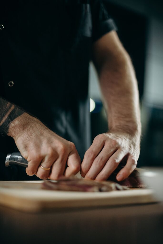 Person sharpening a kitchen knife on a knife sharpener