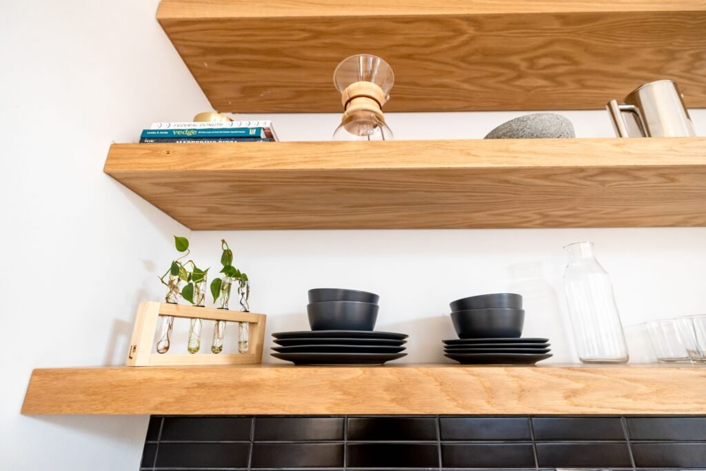 Three floating shelves with decorative items on a living room wall for home decor products
