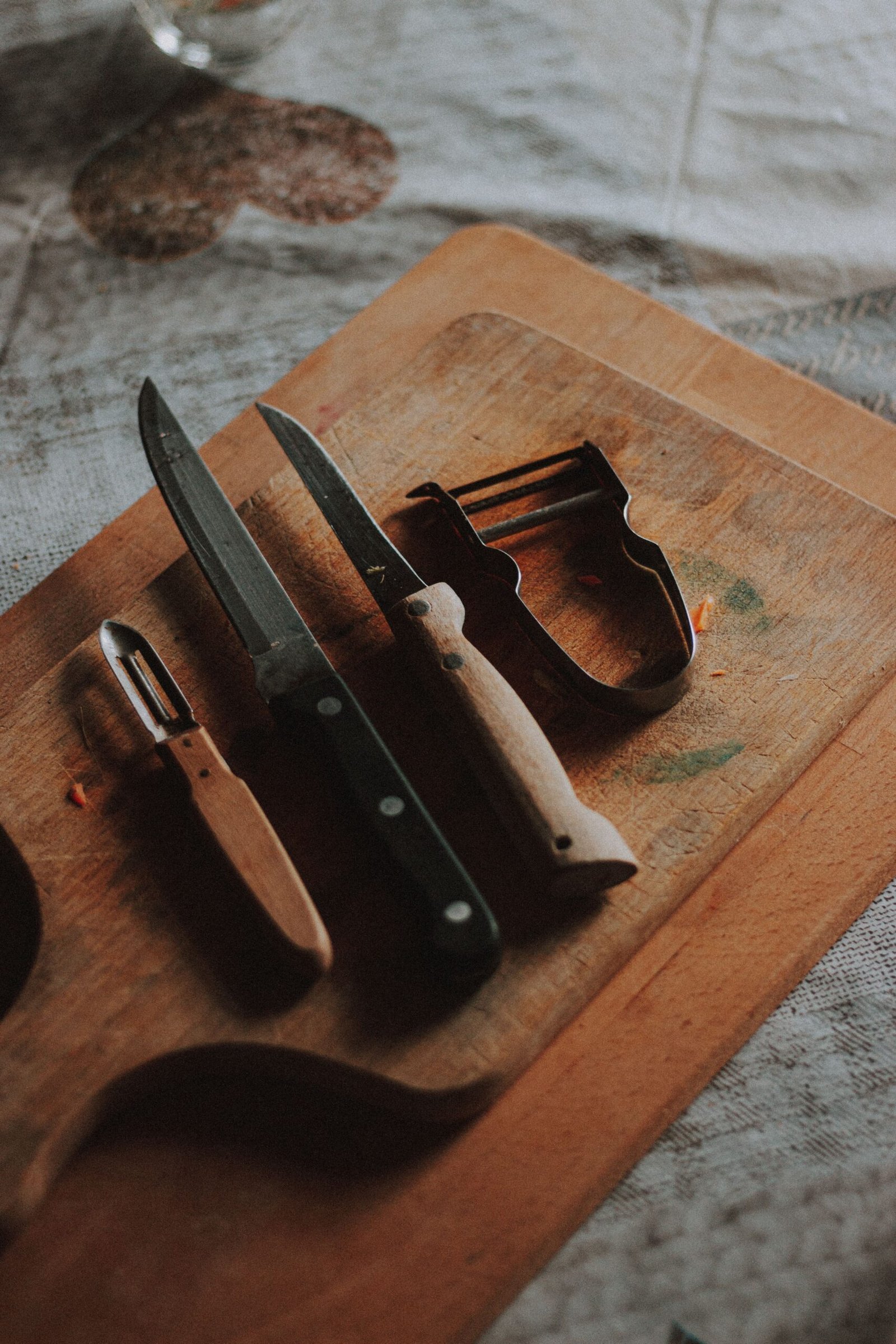 Kitchen cutting board with knives and vegetable peelers