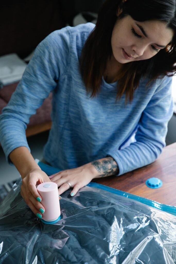 Woman using a vacuum pump to compress a storage bag